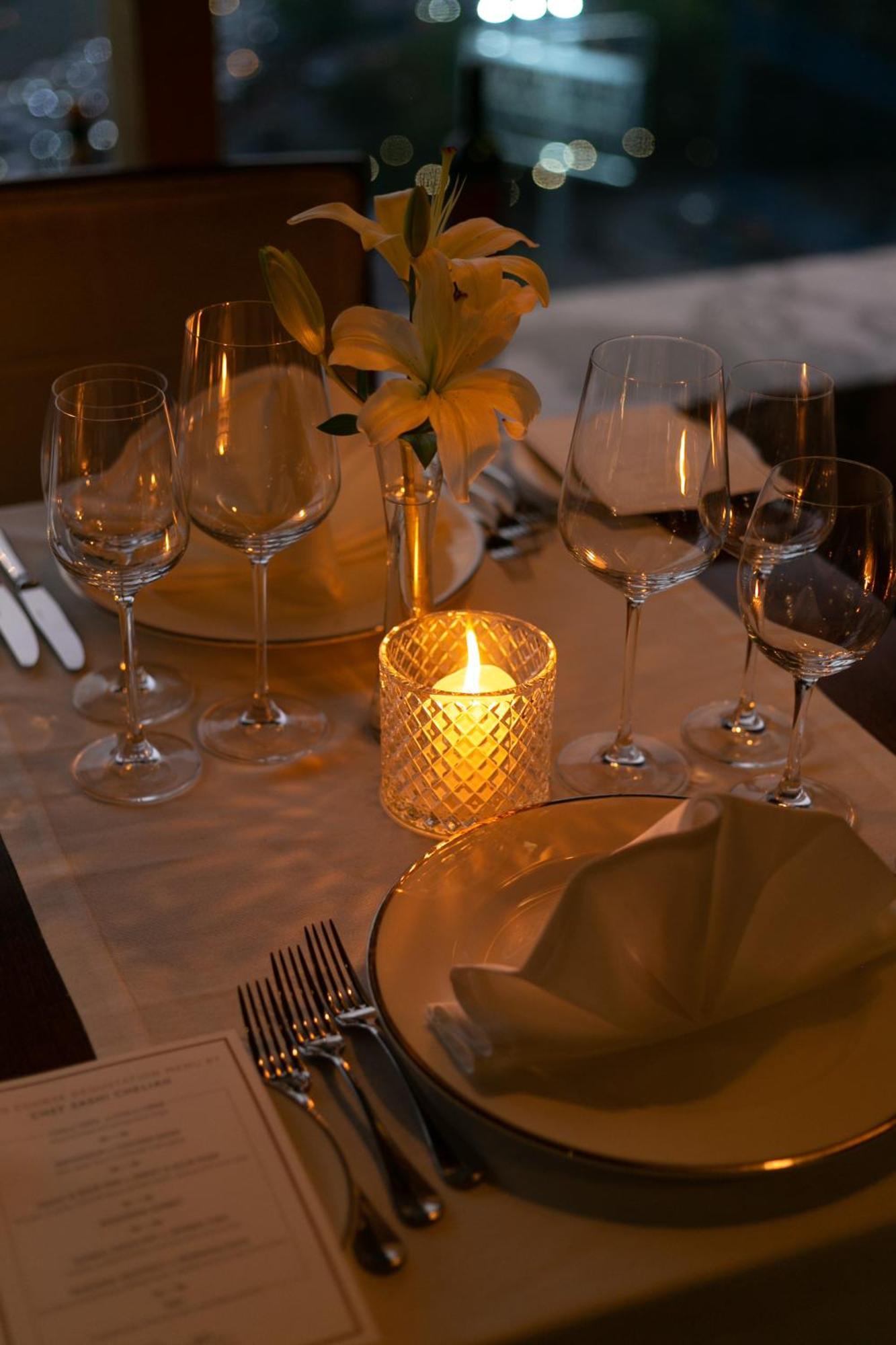 The Leela Ambience Gurugram Hotel & Residences - The Luxury Urban Sanctuary Гургаон Экстерьер фото A candle on a dinner table