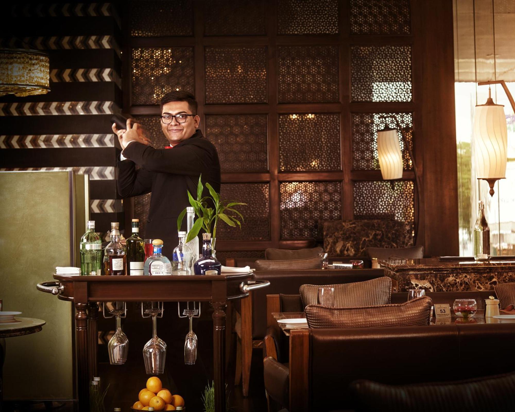 The Leela Ambience Gurugram Hotel & Residences - The Luxury Urban Sanctuary Гургаон Экстерьер фото A bartender at work