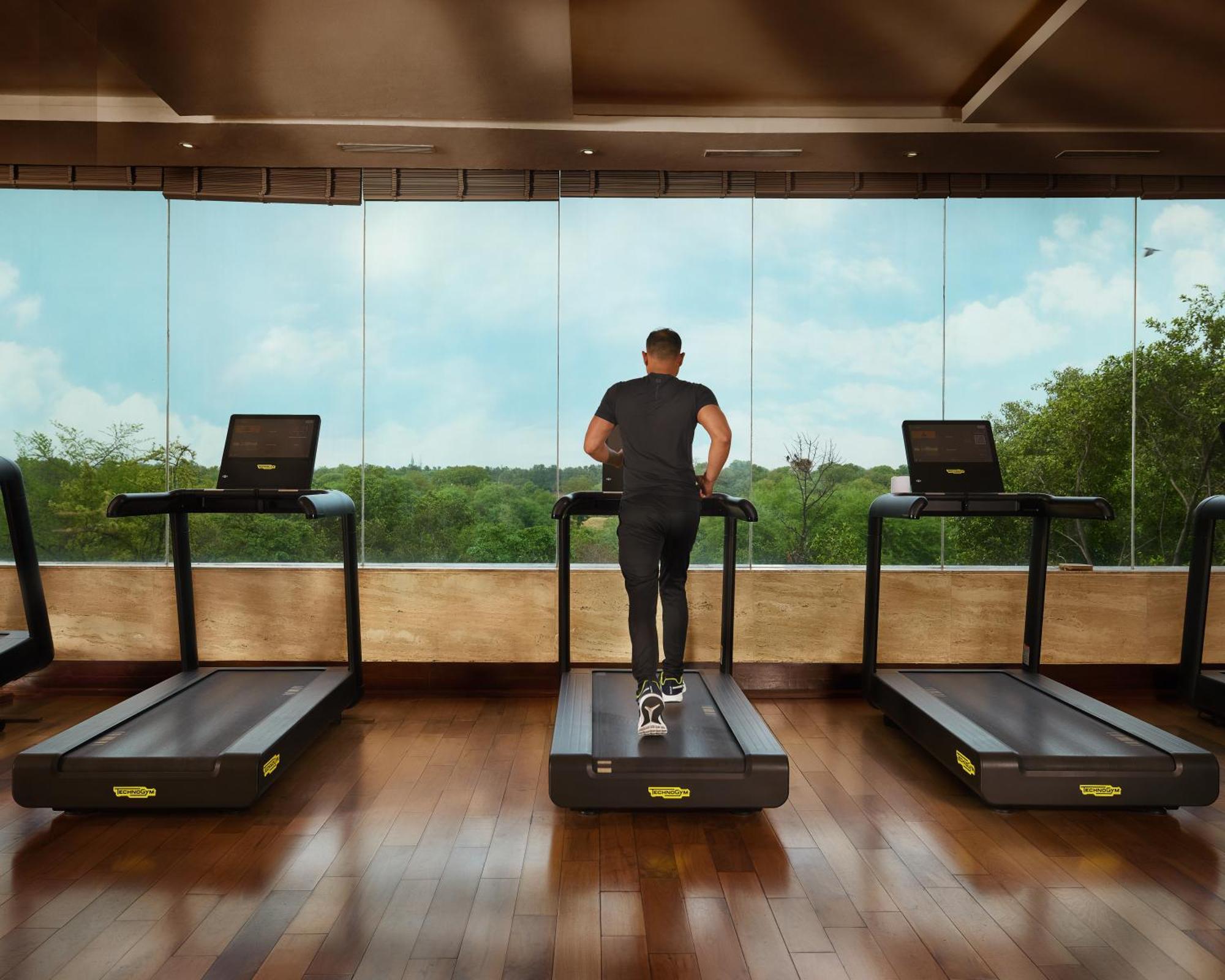 The Leela Ambience Gurugram Hotel & Residences - The Luxury Urban Sanctuary Гургаон Экстерьер фото A man on a treadmill